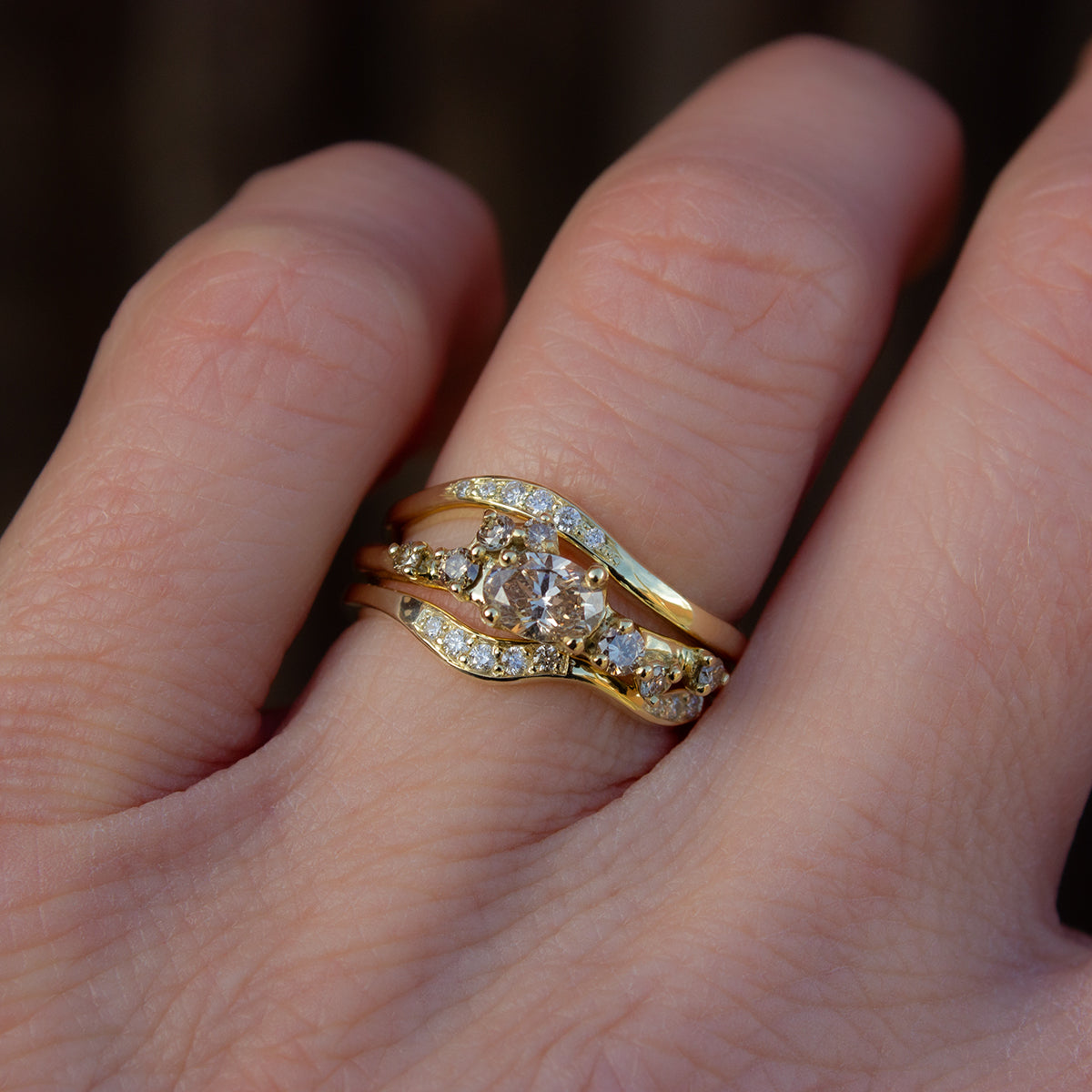 Champagne diamonds engagement ring paired with two organically shaped gold wedding bands with pavé set white diamonds