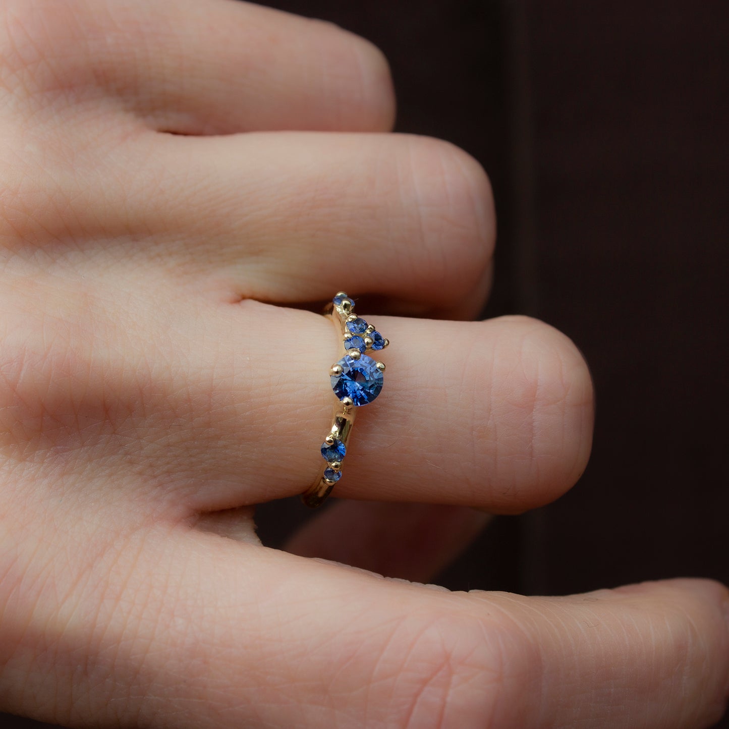Asymmetrical, delicate ring featuring beautiful blue sapphires scattered along a gold band.