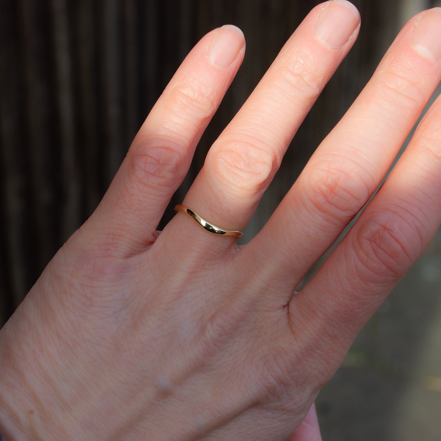 Delicately shaped gold wedding band. Design to gently hug your engagement ring.