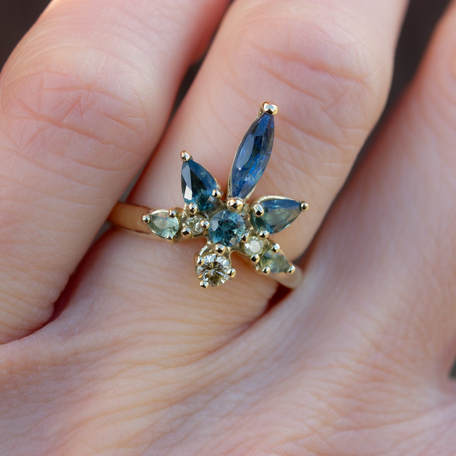 Beautiful coctail ring inspired by water lilies. Featuring blue, teal and green sapphires and yellow diamonds, arranged in the shaped of a flower.