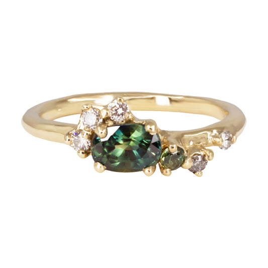 Alternative engagement ring featuring central green parti sapphire, smaller green sapphire and salt and pepper diamonds scattered organically along the band.
