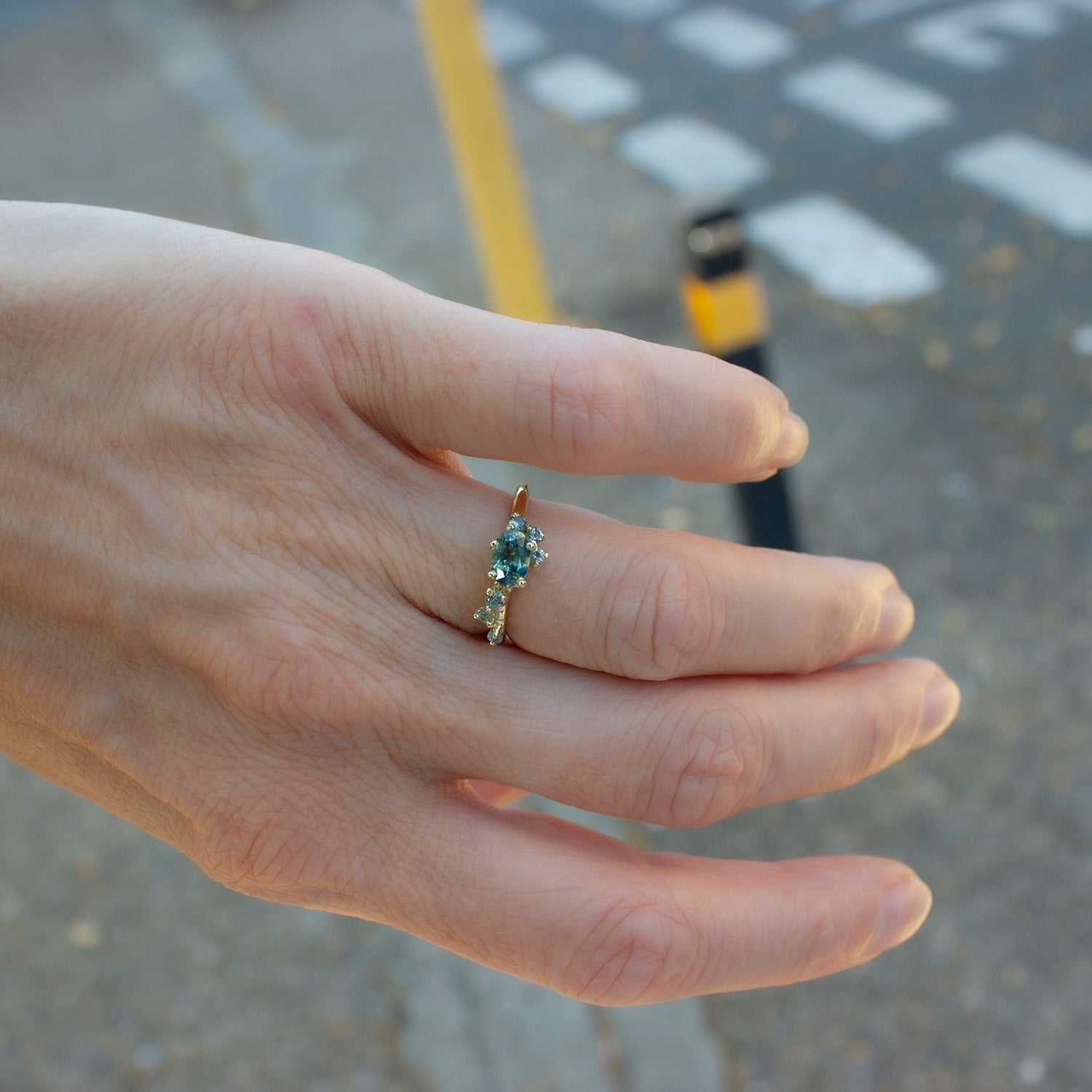 Beautiful alternative engagement ring featuring teal sapphbires scattered organically along the band.