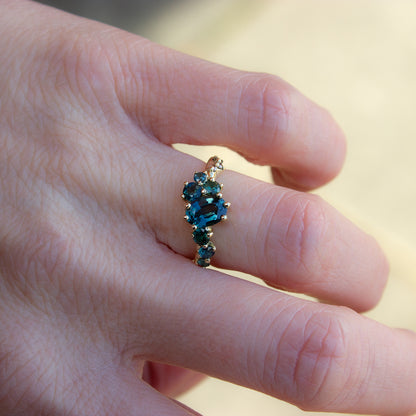 Beautiful, organically shaped alternative engagement or coctail ring. Ring features teal sapphires and champagne diamonds, fluidly scattered along the band.