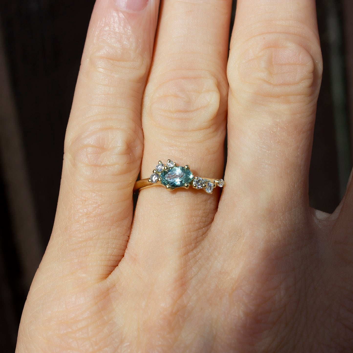 Delicate and beautiful ring featuring teal sapphire and white diamonds. Perfect option as an alternative engagement ring for a modern bride.