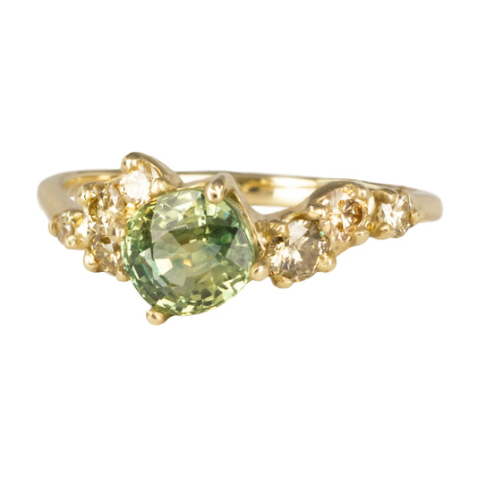 Beautiful, organically shaped ring featuring green cushion cut sapphire surrounded with asymmetrically scattered yellow diamonds.