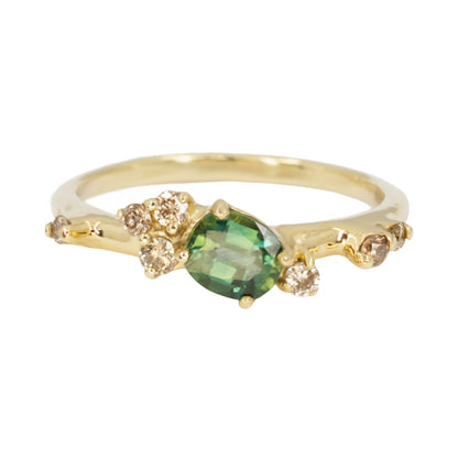 Beautiful, organically shaped ring featuring green sapphire surrounded with asymmetrically scattered champagnediamonds.