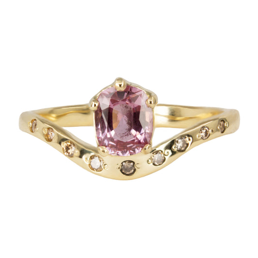 Delicate curved ring in gold featuring cushion cut pink padparadscha sapphire and champagne diamonds.