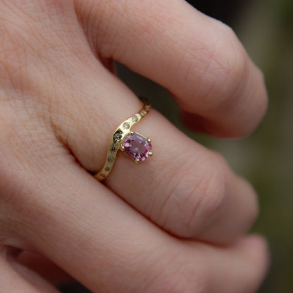 Delicate curved ring in gold featuring cushion cut pink padparadscha sapphire and champagne diamonds. Irena Chmura Jewellery