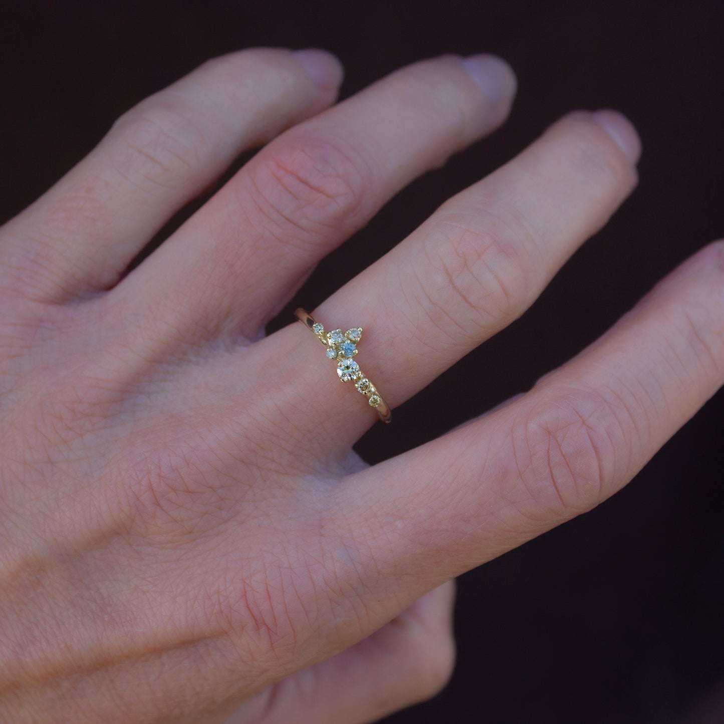 Beautiful, delicate ring featuring organically scattered array of natural yellow diamonds topped with a green sapphire.