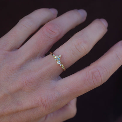 Beautiful, delicate ring featuring organically scattered array of natural yellow diamonds topped with a green sapphire.